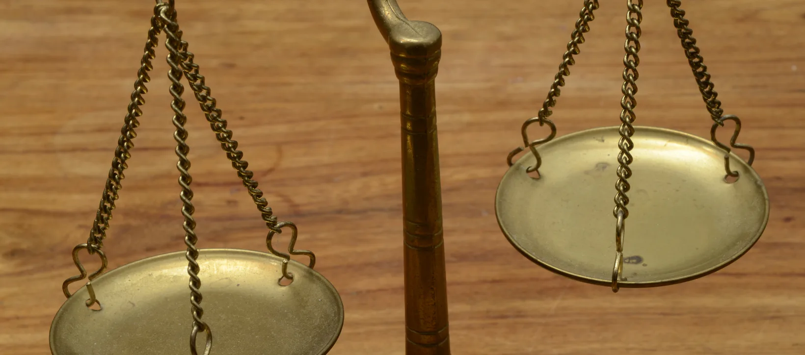 A vintage balance scale on a wooden surface, symbolizing emotional balance, decisions, and life transition.