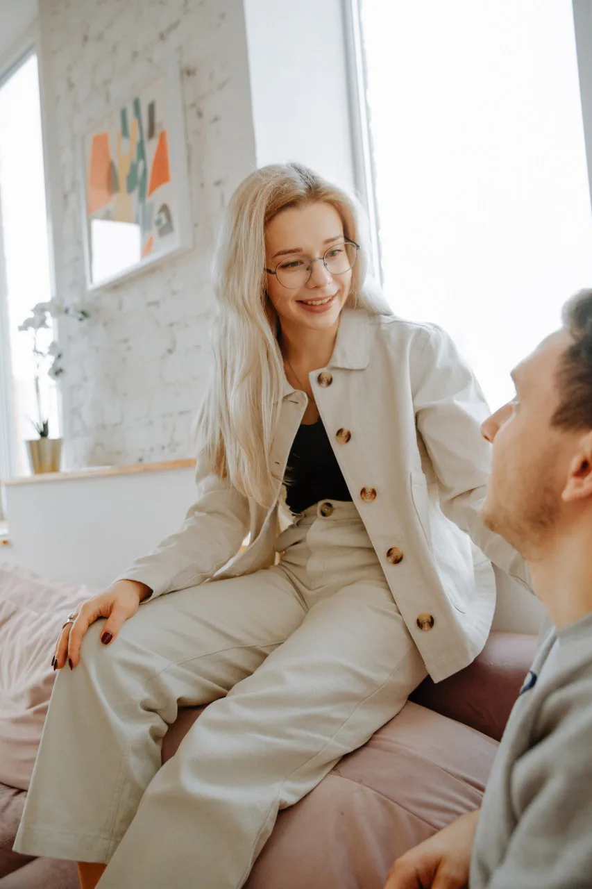 Two friends in conversation indoors, representing supportive friendship, emotional honesty, and personal growth after graduation.